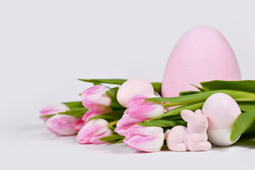 Easter arrangement with tulip flowers, pink easter bunny and painted eggs