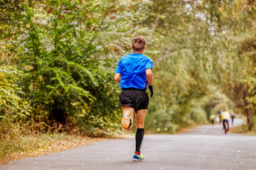 back man runner leader marathon race running in autumn park