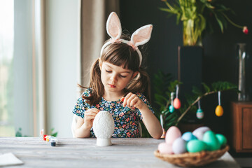 Little girl painting easter egg