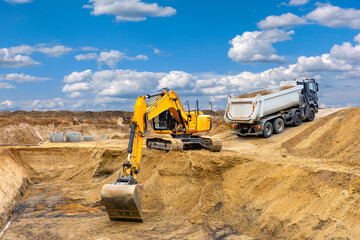 excavator is working and digging at construction site - obrazy, fototapety, plakaty