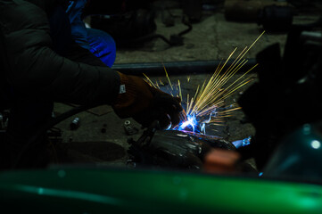  welder performs welding works of metal structures for custom cars