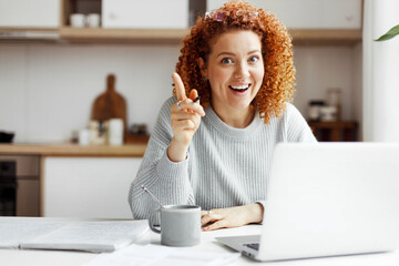 Eureka! I've got brilliant idea! Excited happy female entrepreneur showing index finger up after...