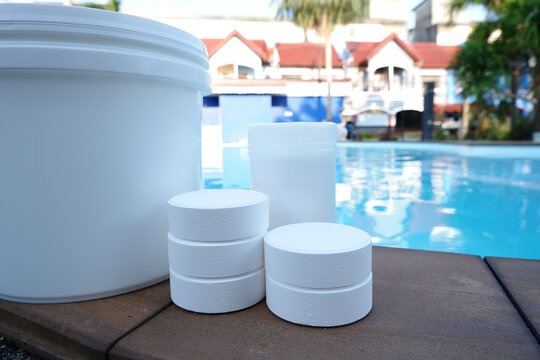 White chlorine tablets for swimming pool disinfection, pool water maintenance.