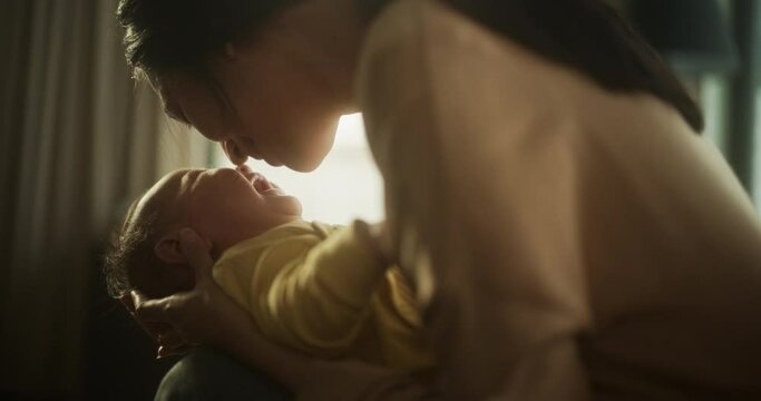 Asian Woman New to Motherhood Having Special Moment with her Baby at Home . Intimate Moment Between New Mother and Infant Showing Motherly Love, Tenderness and Unconditional Affection