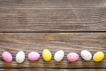 Multicolored Easter eggs on a wooden background, flat lay.