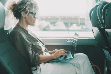 One woman working on bus with laptop during passenger travel. Businesswoman modern lifestyle people digital nomad. Smart working with computer sitting on seat in transport vehicle, Middle age female