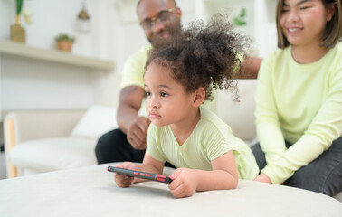 Little children play and learn things in the wide world on tablet. with parents to supervise and help in the living room of the house on vacation