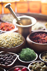 Natural medicine background. Assorted dry herbs in bowls, mortar and plants on rustic wooden table.
