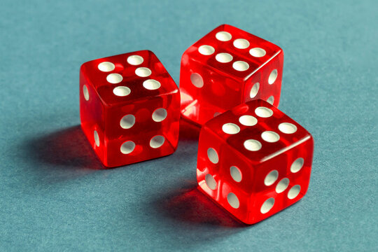 Random number generator. Three red dice with numerical values lie in a chaotic order.