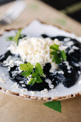 Ukrainian dumplings with cuttlefish ink. Rub butter on top. Traditional food