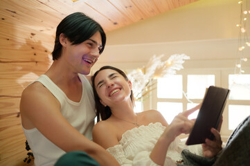 Young couple having fun and enjoyment reading folk novels to one another in the morning in the...