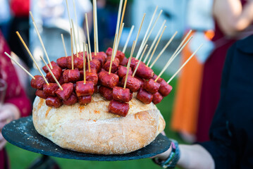All kinds of appetizers, tapas, canapés, cold meats, cheeses and vegetables at an event, wedding, cocktail, waiter serving guests.