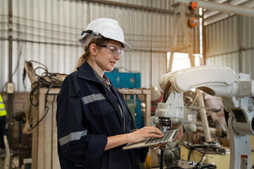 engineers and technician using laptop checking and repair pressing metal machine at factory,...