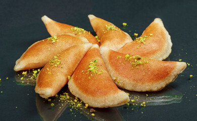 Obraz na płótnie Canvas Qatayef, Traditional Arabic Ramadan Sweets with pistachio on black background