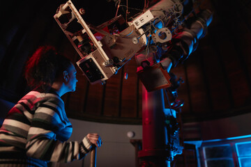 Astronomer with a big astronomical telescope in observatory doing science research of space and...