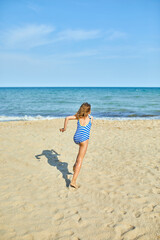 Fototapeta na wymiar Happy, joyful little girl run on the beach