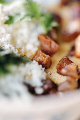 Macro photo of traditional Ukrainian dish Banosh. Corn porridge in butter sprinkled on fried lard and sheep's cheese