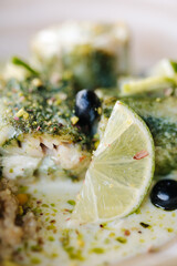 Macro photo of stuffed fish with a creamy sauce and white cinema as a side dish. Wooden table