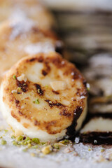 Macro photo cheesecakes fried in butter with creamy chocolate cream, grated nuts on top