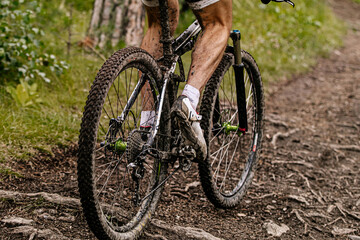 Fototapeta na wymiar close up dirty feet cyclist and mountain bike riding on forest trail
