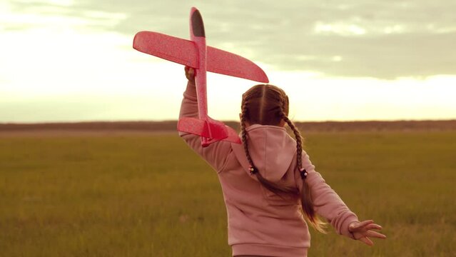 little cheerful child girl with airplane runs into sunset. happy family concept. childhood dream becoming airplane pilot. silhouette child playing with airplane. fly kid dream plane. run child pilot
