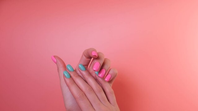 Simple two color gel nail design. One hand with pink nails, second with turquoise nails