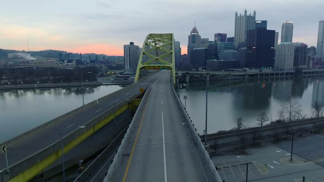 Driver POV exiting Fort Pitt Tunnel onto Fort Pitt Bridge revealing beautiful Pittsburgh, Pennsylvania skyline during sunrise,