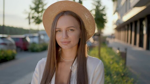 Closeup face of beautiful happy smiling young hipster woman wearing hat with long hair. Portrait of gorgeous beautiful girl looking to camera smile stand in the city streets summer Enjoys Life Fun.