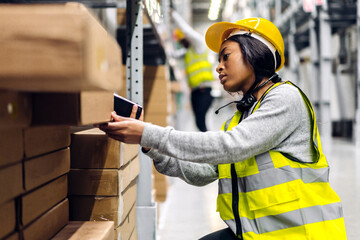 Portrait of african american engineer woman scanning package with barcode scanner check goods in...