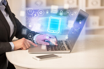 Hands working on laptop with digital icons