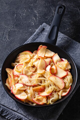 fried onion and red apple slices on skillet