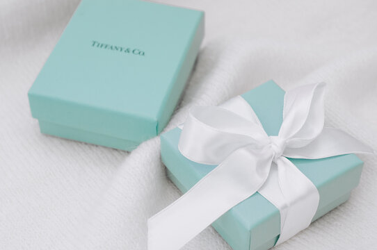 Two brand Tiffany boxes, one with silk ribbon on the knit creamy canvas.