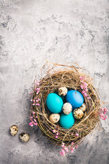 Fototapeta na wymiar Happy Easter - nest with Easter eggs on grey background with copy space