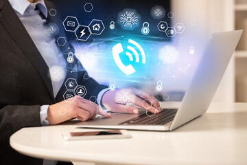 Hands working on laptop with digital icons