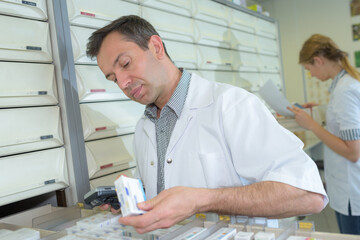 male pharmacist using digital tablet at work