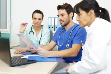 team of doctors working on laptop in medical office