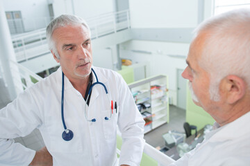 senior doctors talking on a bright stairway