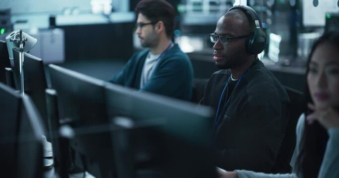 African American QA Engineer Finds and Fixes Bugs in a Product or Program Before the Launch, Collaborating and Talking with Colleague. Young Black Specialist Working in Advanced Technology Industry