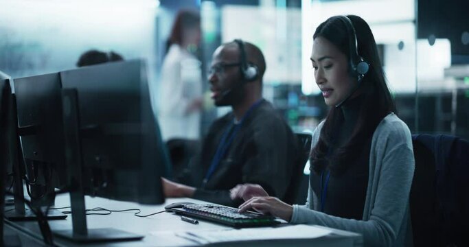Help Desk Specialist Answering a Call, Providing Technical Support to Client Experiencing Computer Hardware and Software Issues. Asian Female Using a Headset to Have a Conversation with a Tech Team