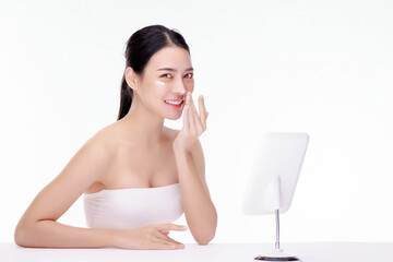 Close up beauty portrait of a smilling beautiful woman wairing white shirt covers only the chest.applying face cream and look at camera. isolated over white background.