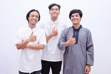 Muslim people in islamic wear giving thumbs up, isolated over white background.