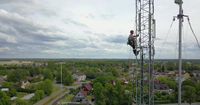 Telecommunication Technician Working at Height on 5G Antenna Near Residential Area &ndash; Aerial View