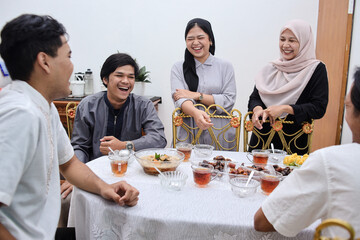 Young asian muslim people having dinner break fasting together at home during ramadan