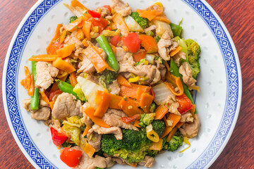 Traditional chinese stir fried meal with pork meat, broccoli and carrots