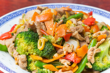 Traditional chinese stir fried meal with pork meat, broccoli and carrots