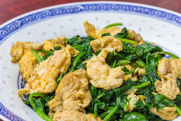 Chinese stir fried vegetarian meal with egg and spinach