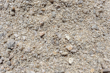 Detail of surface texture with small pebble rock on dirty ground