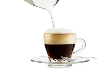 Making cappuccino in glass cup with milk frother on white background.