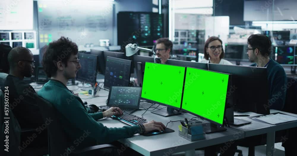 Aufkleber Group of Diverse Multicultural Men and Women Working on Desktop Computers in a Research Center. Young Software Developer Working on a Computer with Two Green Screen Mock Up Displays. Static Footage