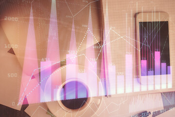 Multi exposure of forex graph hologram over desktop with phone. Top view. Mobile trade platform...